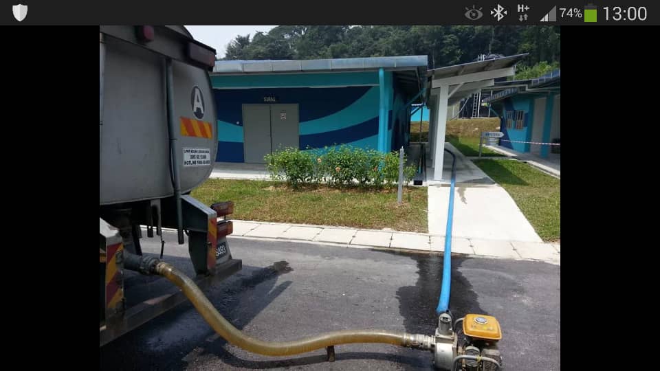 Transfer hose and portable pump connected to a water tanker