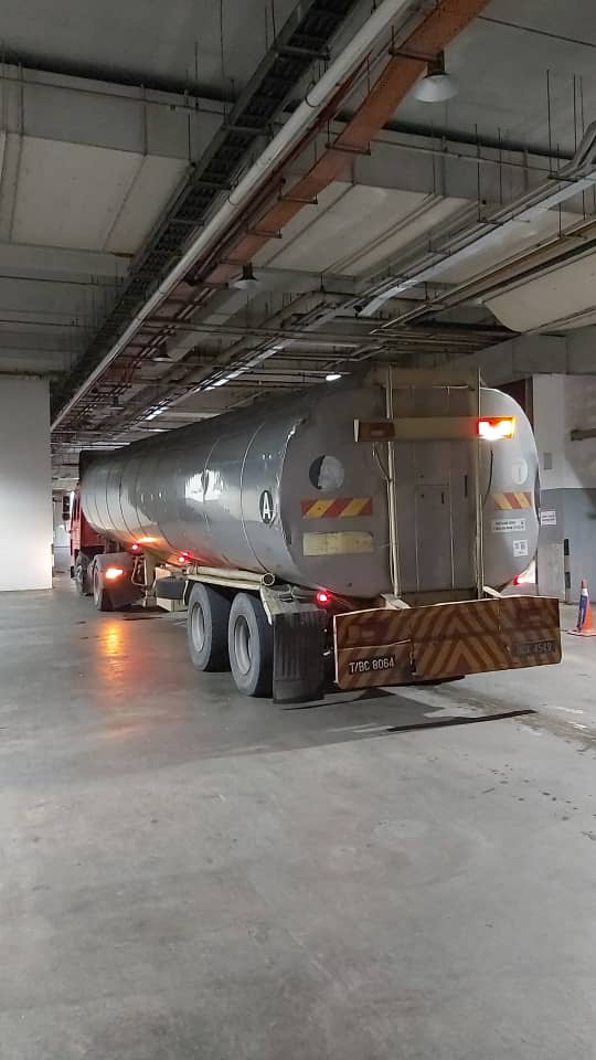 Water tanker positioned inside a covered receiving area